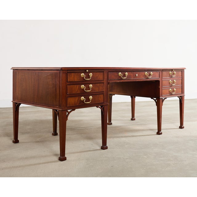 A stately Georgian style mahogany executive writing table or desk crafted by Baker Furniture in the United States. The...