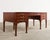 A stately Georgian style mahogany executive writing table or desk crafted by Baker Furniture in the United States. The...