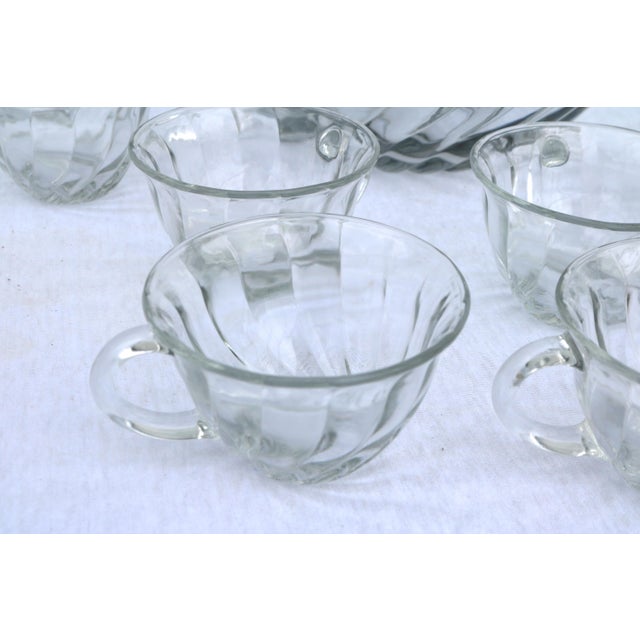 The Anchor Hocking Victoria Optic Swirl Clear 14” Punch Bowl and 8 Cups set is a vintage piece of traditional American...