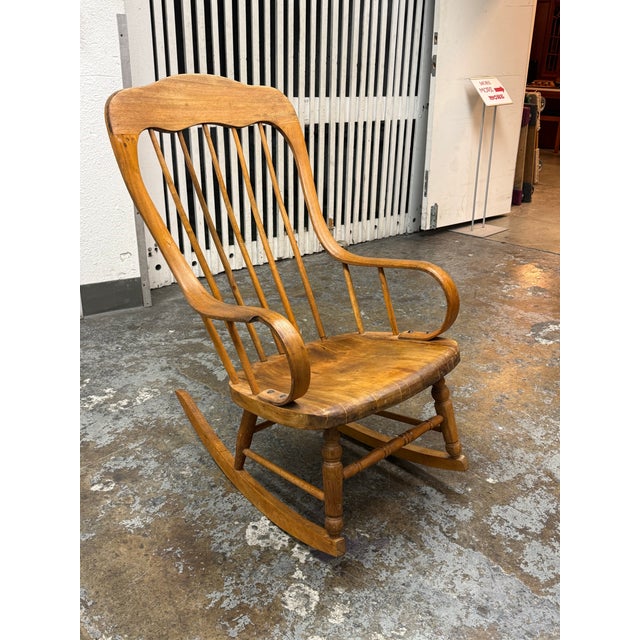 Design Plus Gallery presents a Vintage Windsor Style Arm Rocker. This handcrafted wooden rocker has a tall, contoured back...
