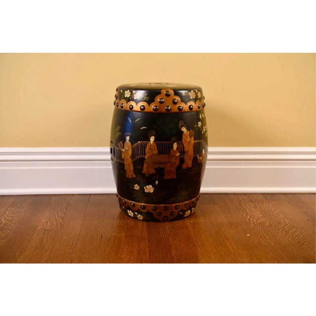 A vintage Chinese barrel-form ceramic garden stool in a black glazed finish with gold scalloped cloud motifs with raised,...