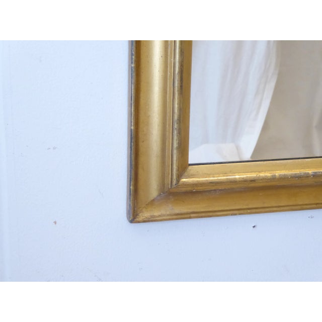 19th Century giltwood bolection mirror with rubbed goldleaf finish, 44"H x 27.5"W.