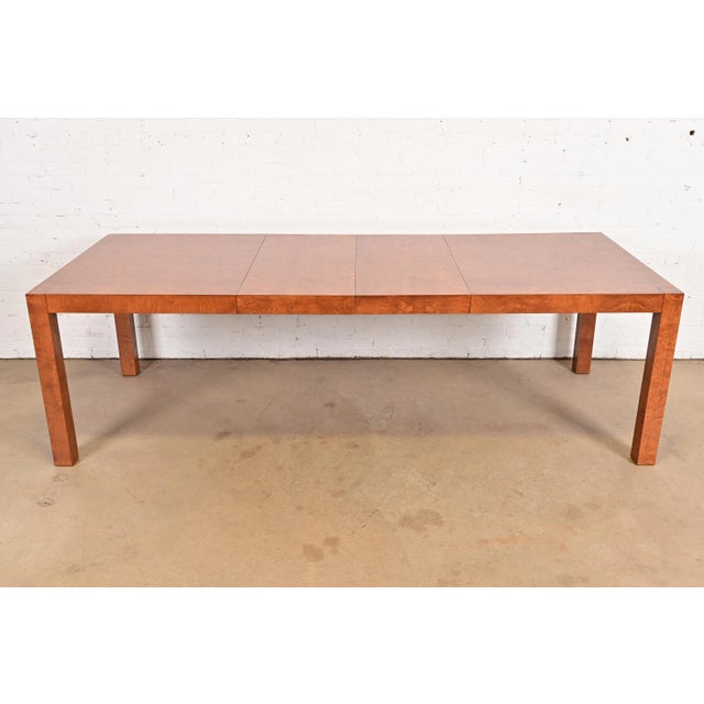 An outstanding Mid-Century Modern Parsons extension dining table in gorgeous book-matched burled olive wood In the manner...