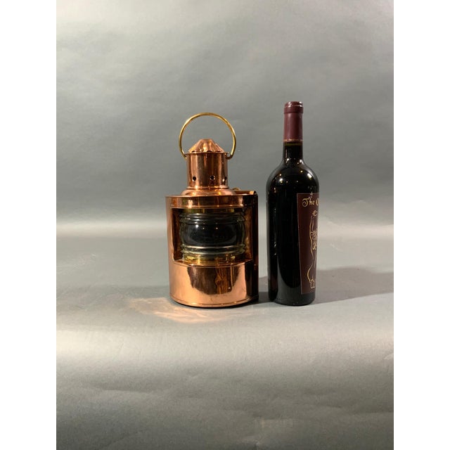 Solid copper ships lantern with Fresnel glass lens. No burner. With vented top, carry handle, and hinged door on rear....