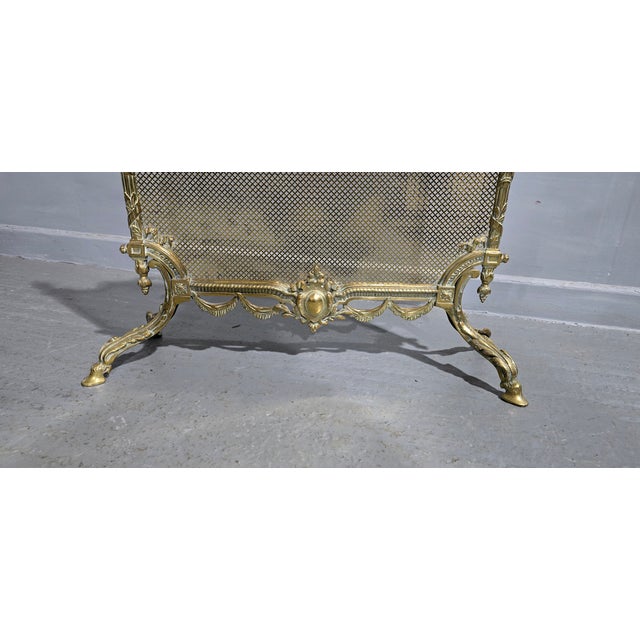 A very good Victorian gilt brass fire guard with wreath handle hoof feet and pierced brass screen, in overall excellent...