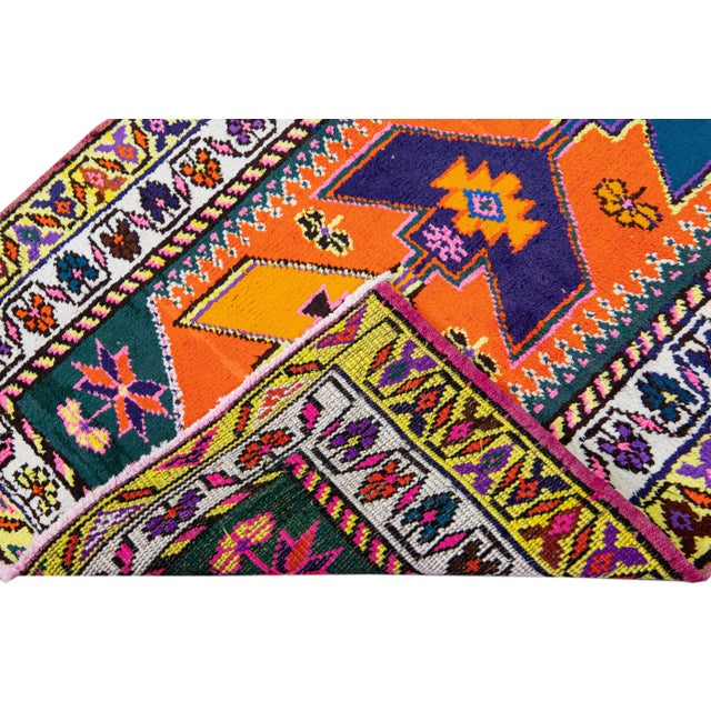 Beautiful vintage Turkish hand-knotted wool rug with an orange field. This rug has a white and yellow designed frame and...