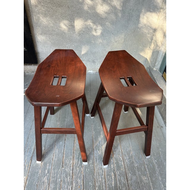 Pair of Vintage Studio Crafted Mission Style Saddle Stools. Pair of hand crafted Mission style stools in a dark mahogany...