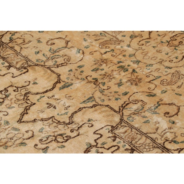 Hand knotted in wool circa 1930-40, this oversized 11x21 antique Kerman Lavar rug is an especially rare and exciting new...