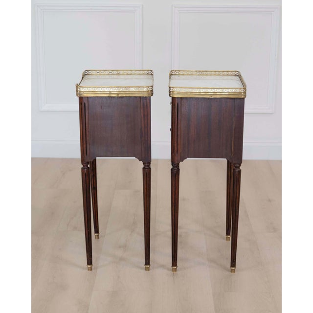Made in France in the twentieth century, this pair of Louis XVI style bedside tables, each with two drawers at the front...