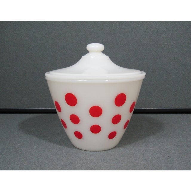 A delightful piece of mid-century American kitchenware, this vintage Fire King grease jar pairs clean white milk glass...