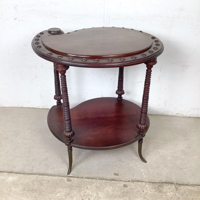 The kidney form has a long history in English furniture, and this antique mahogany two-tier example carries that tradition...