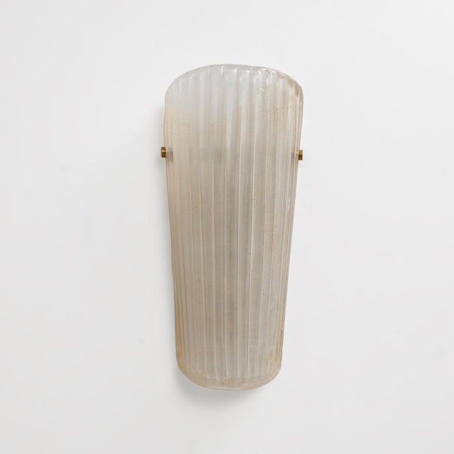 An elegant pair of murano glass wall sconces, handcrafted from translucent glass with delicate gold dust inclusions. The...