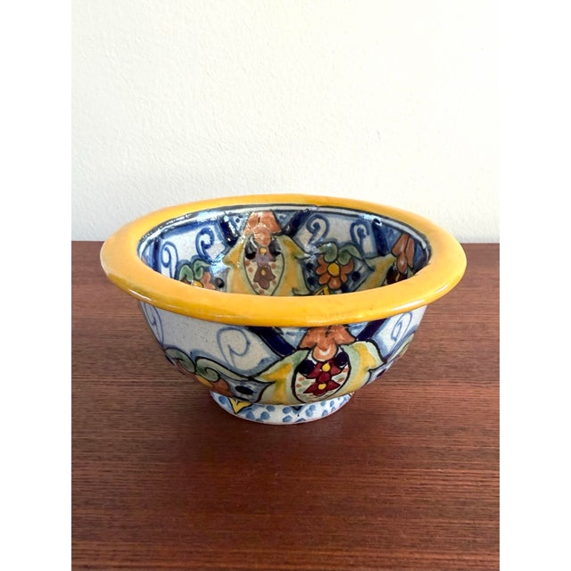 Colorful hand painted Mexican pottery bowl in the traditional Talavera style, characterized by intricate geometric,...