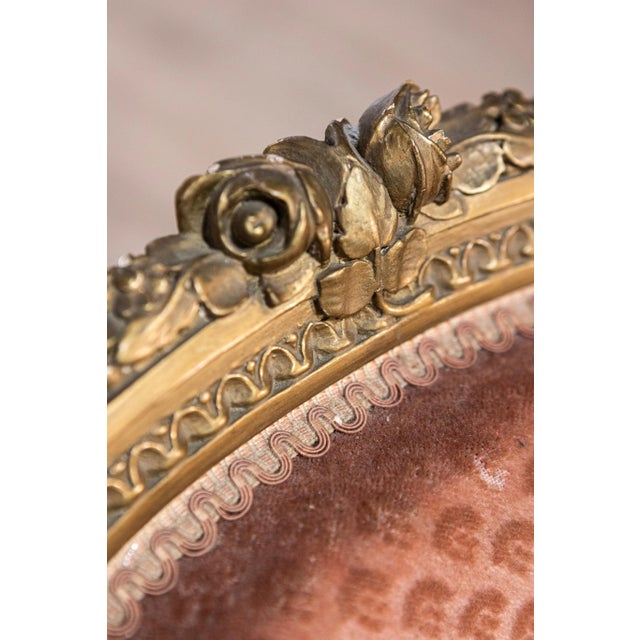 A pair of French Louis XVI style gilded wood bergères chairs from the 20th century with carved décor and fluted legs....