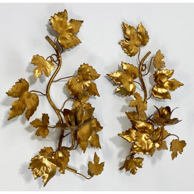 Rich vintage pair of Hollywood Regency style Italian Tole gilt wall sconces, each holding a single taper surrounded in...