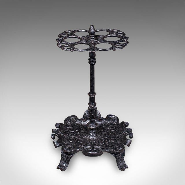 This is an antique reception hall umbrella stand. An English, cast iron six hoop stick rack, dating to the late Victorian...