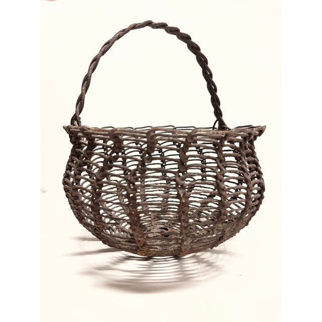 Sturdy woven wire basket with a braide handle for eggs or gathering in the garden. Folk art, American.