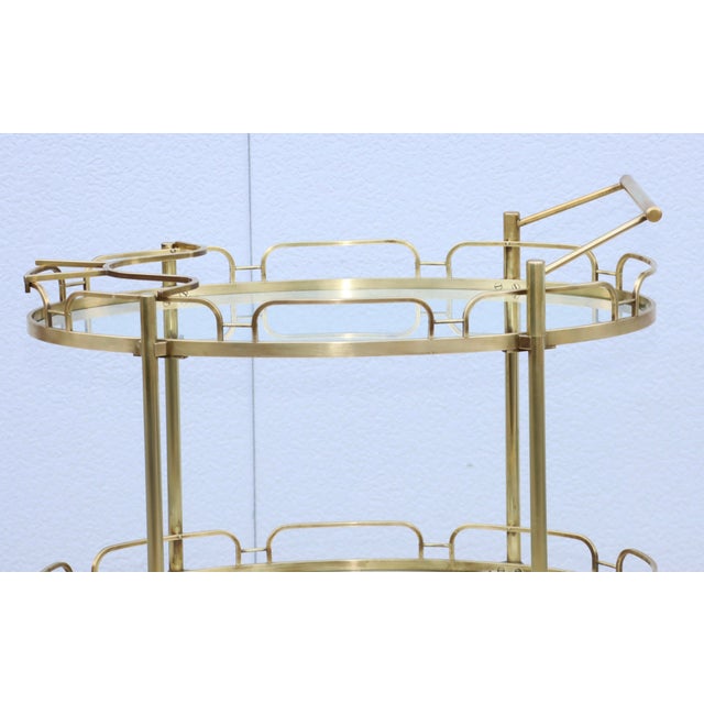 Amazing 1950's solid brass two tier oval bar cart by Maxwell Phillips, with removable handle and original bottle holder,...