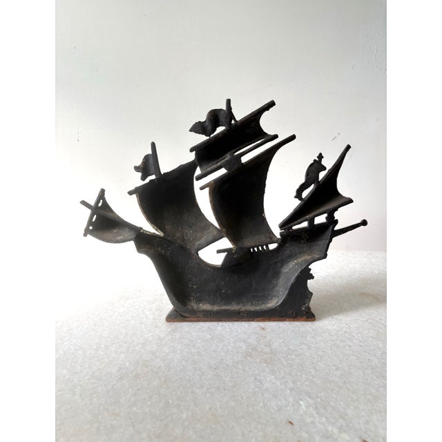 Heavy cast iron with original or vintage cold-painted polychrome finish. Modeled as an antique caravel/galleon riding...