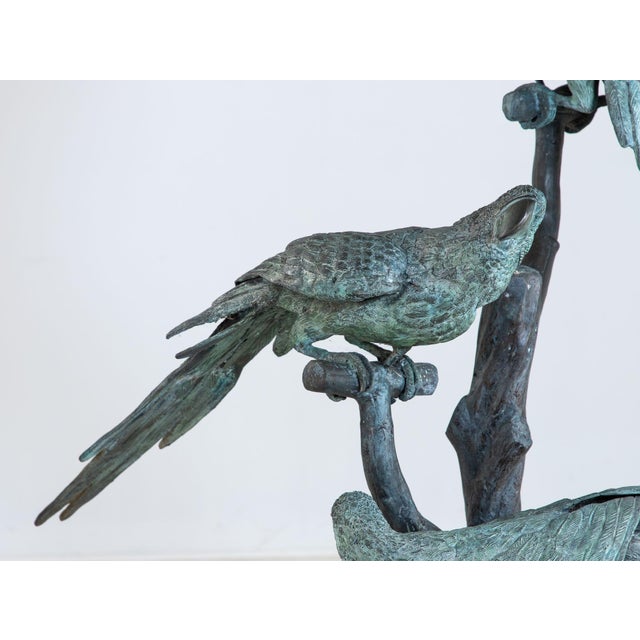 This 1950s Italian bronze sculpture depicts three parrots perched on a branch with detailed feathers and a warm patinated...