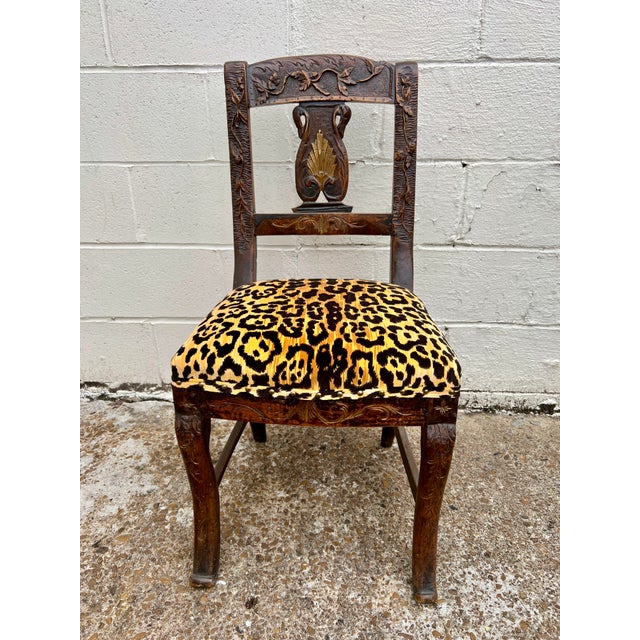 Carved sturdy side chair with leopard seat fabric.