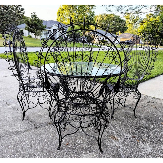 Vintage wrought iron glass top table 4 chairs Table is: 48'' across 29" high Chairs are 50" high on the back and 17" high...