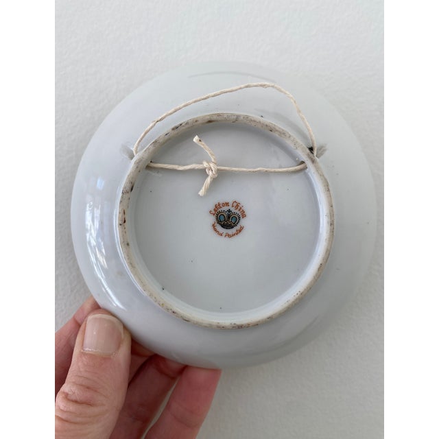 Beautifully hand painted bluejay on flower branch. Plate has a light green background.