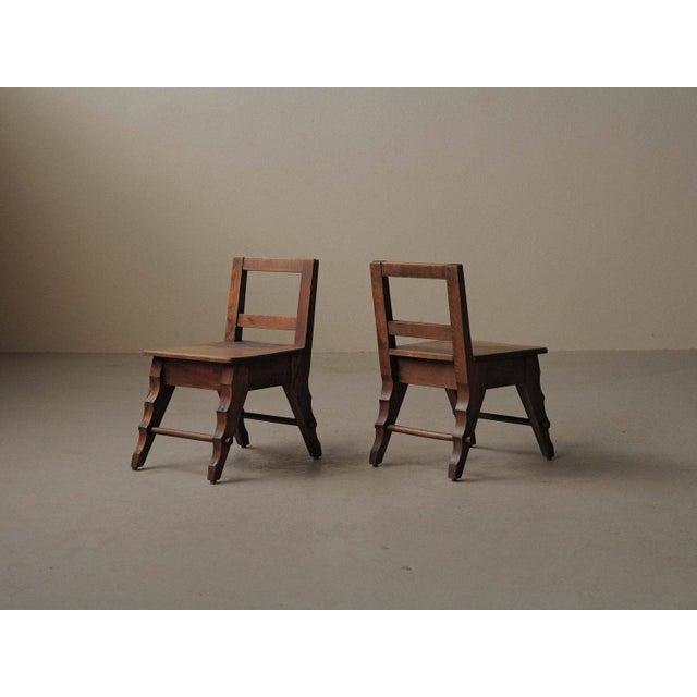 Pair of handcrafted solid oak chairs with a distinctive sculptural character. Each features four splayed, shaped legs...