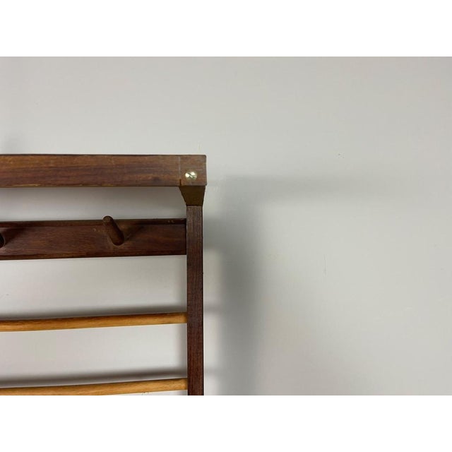Rare Mid-Century Modern wall-mounted coat rack, dating from approximately the 1950s–1960s, featuring a beautifully...