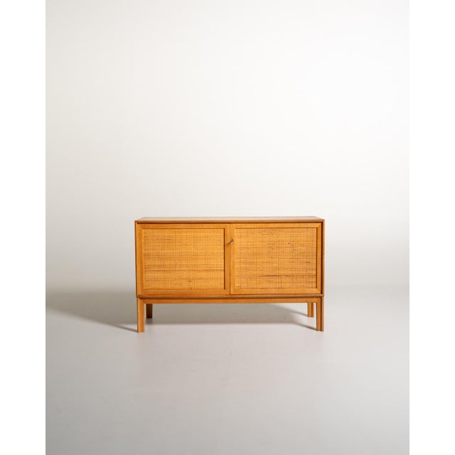 Oak frame with two doors covered in woven rattan and an interior divided into two compartments. "Norrland" sideboard...