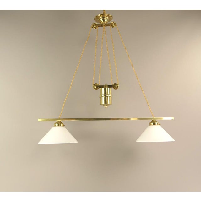 with the help of the pulley system, the luminaire can be manually adjusted in height from 85 to 120 cm. The two opal...