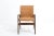 Armchair in brown sky with wooden armrests This piece is attributed to the mentioned designer/maker. It has no attribution...