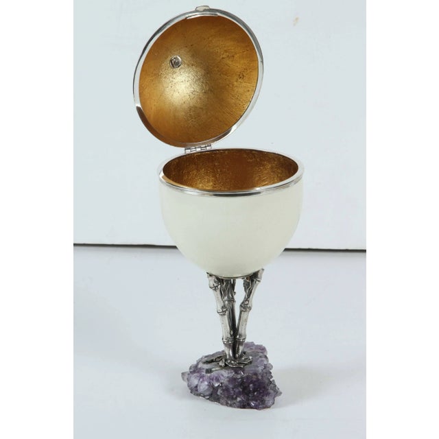 Large, hand decorated ostrich egg container featuring a gilded interior. The whole mounted on a sterling silver pedestal...