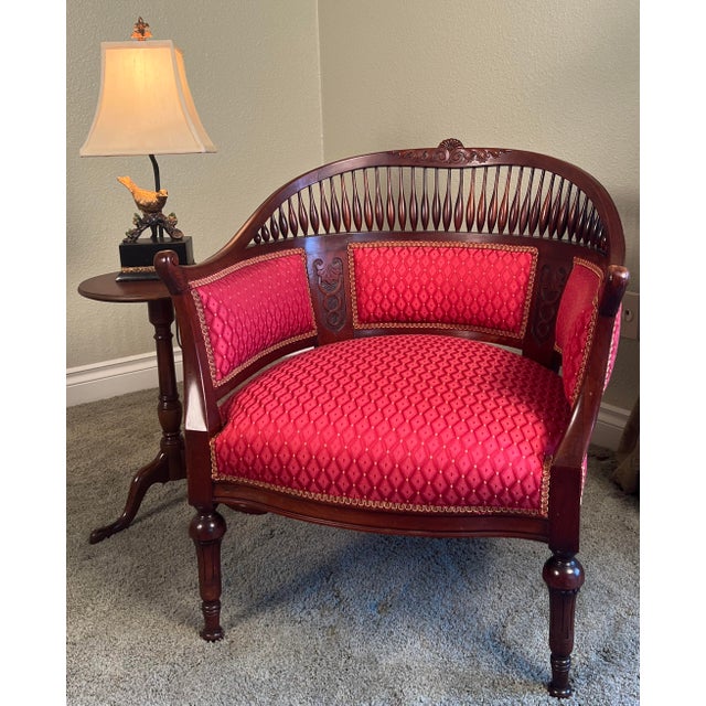 Elegant Edwardian mahogany barrel back conversation chair dating to approximately 1900–1910. The frame features a carved...