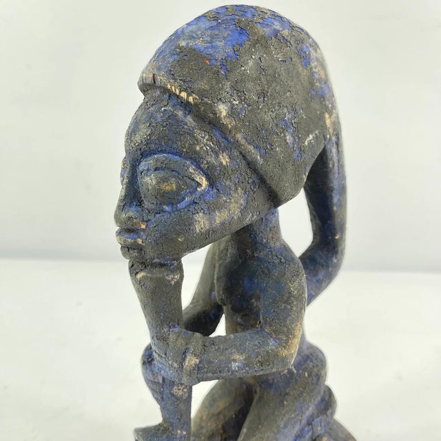 This carved wooden figure represents a devotee of Shango, the powerful Yoruba orisha of thunder, lightning, fire, and...