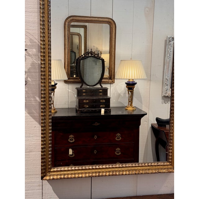 A large rectangular gilt wood mirror with a carved and beaded molding frame. The gilt shows good age and patina...