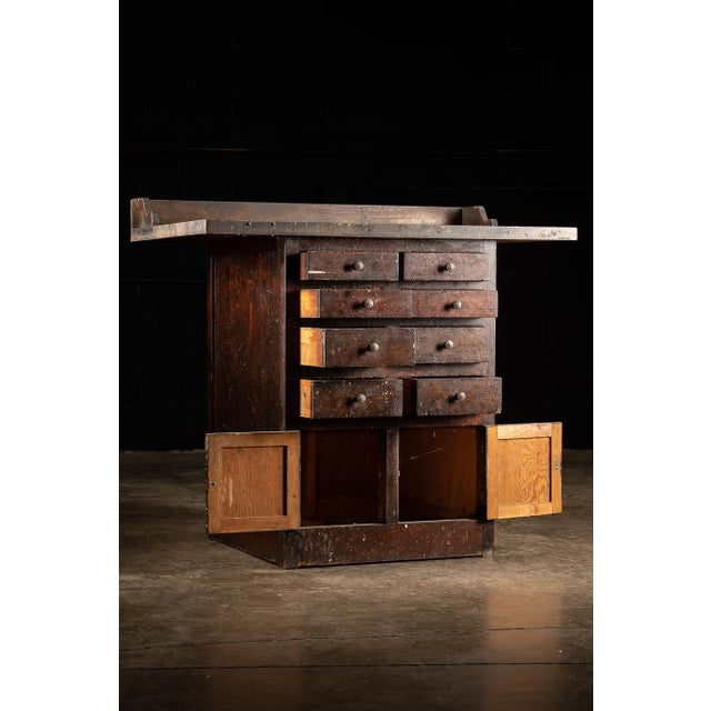 This industrial workbench features a large work surface area with a back board as well as eight drawers and two cabinets....