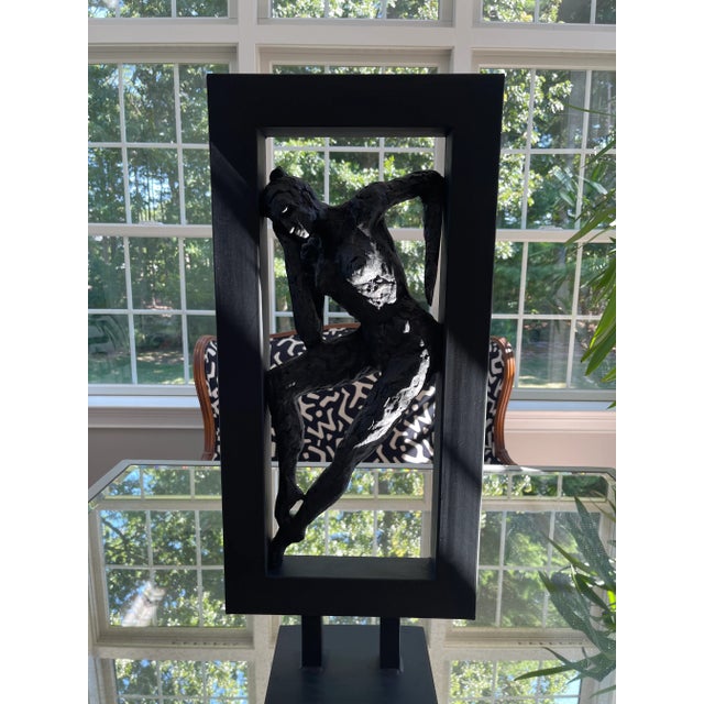 Modern abstract sculpture of a female form leaning inside a painted black metal frame. This piece is unmarked. A beautiful...