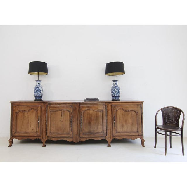 An exceptionally large provincial French sideboard or enfilade dating from around 1800. Louis XV style. Crafted from solid...