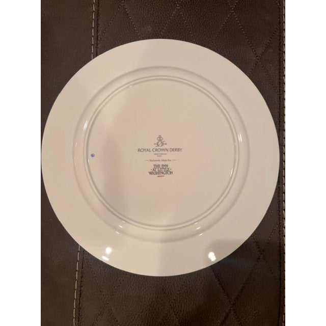 This elegant porcelain charger features a detailed blue-and-white pastoral design depicting the iconic landscape and...