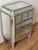 Cute small mirrored commode with three small drawers in the upper level, on tapered legs. In Hollywood Regency style....