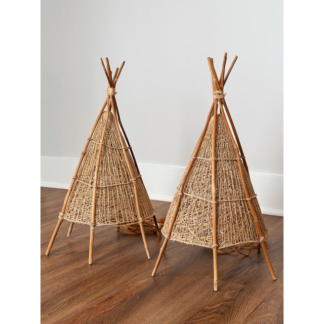 This pair of artisanal wicker woven table lamps is modeled after the teepee, a shape that feels both sculptural and deeply...