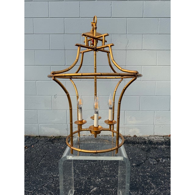 Elevate your space with this stunning Hollywood Regency style faux bamboo lantern chandelier by premier decor brand...