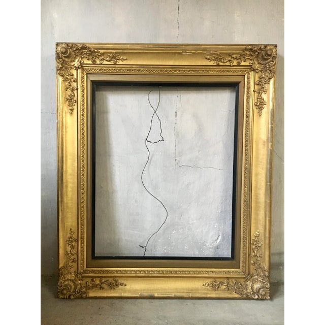 This large antique gilt wood and gesso frame. is intricately designed with shell motif corners. corners. Stately with...