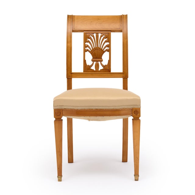 Directoire style antique French chairs made with solid wood construction that has been finished with a lustrous French...