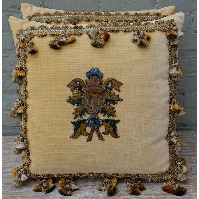 A sophisticated pair of custom decorative pillows featuring rare 18th-century embroidered textile fragments, hand-applied...
