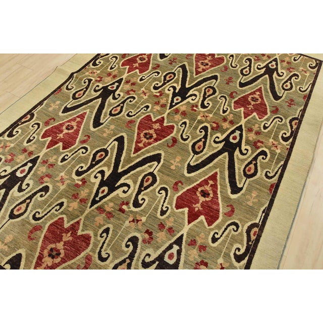 A traditional Ikat rug hand-knotted with fine wool on a cotton foundation. This rug features a botanical design set...