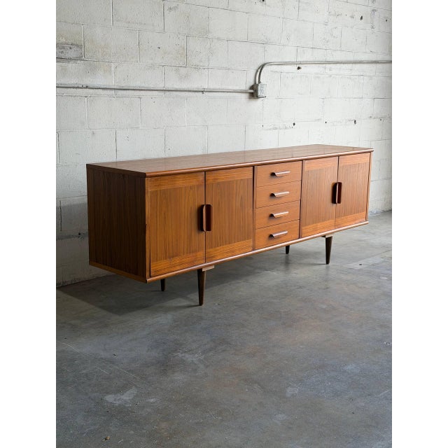 This minimalist storage piece features an elongated rectangular silhouette balanced beautifully on tapered legs. The front...