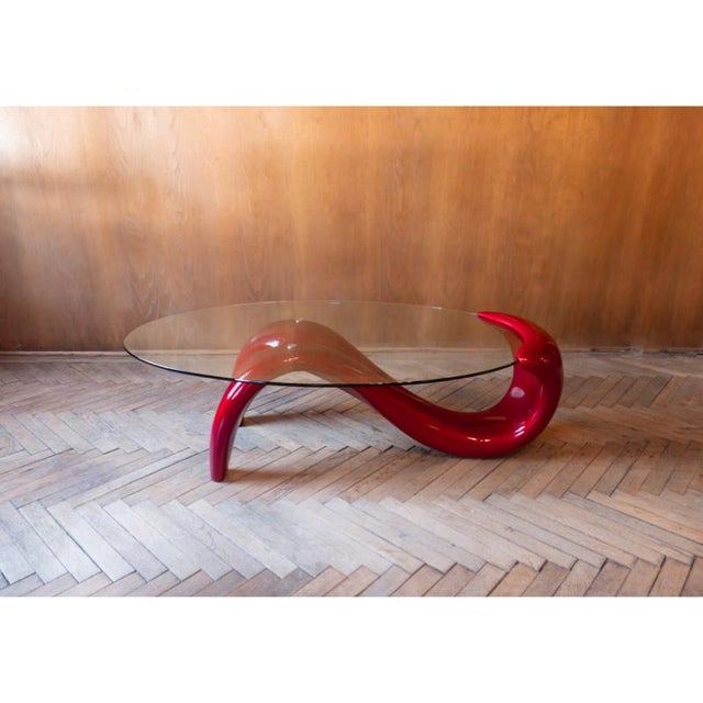 Stunning postmodern glossy lacquered red coffee table with a base in form of a woman’s body and a glass table top. This...