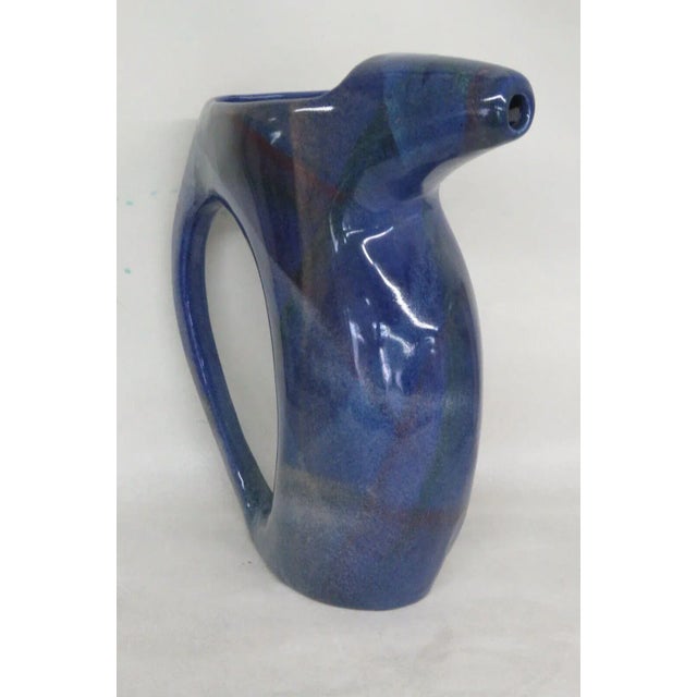 This unique Pitcher is made of ceramic. This pitcher has an abstract style design in a beautiful purple color with subtle...